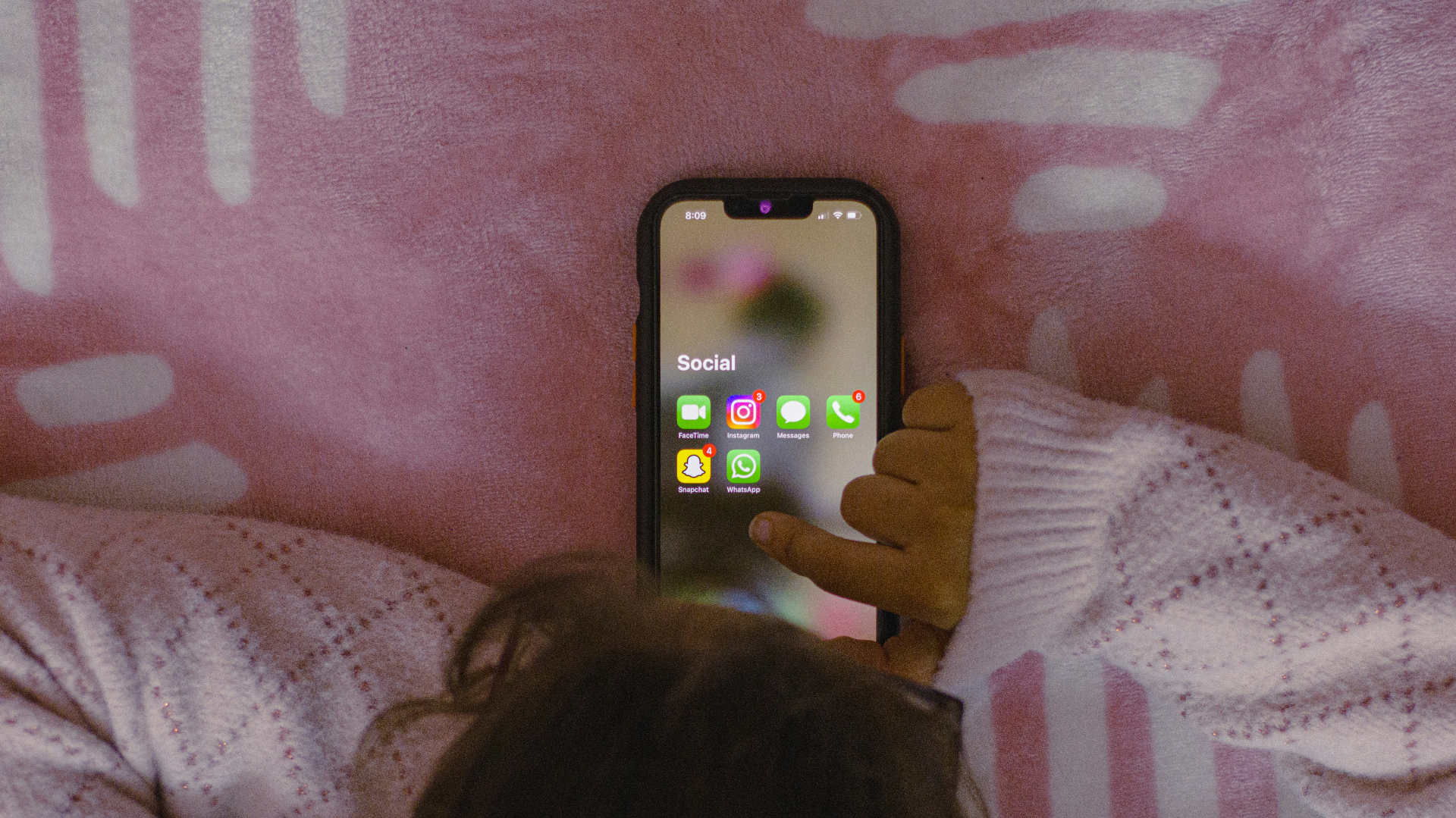Enfant devant son smartphone avec des réseaux sociaux